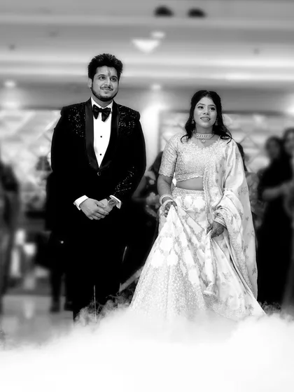 A dramatic black and white shot of the couple's entrance at their Roka ceremony. The use of smoke effects adds a cinematic touch, making their entry feel magical and unforgettable.