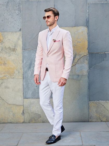 A full-length view of the pink linen suit, showcasing its slim-fit trousers and the sharp cut of the jacket. It's a modern take on classic tailoring.