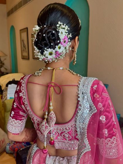Here's a closer look at the floral arrangement, featuring a mix of white and pink flowers with delicate pearl accents, creating a textured and romantic bridal updo.