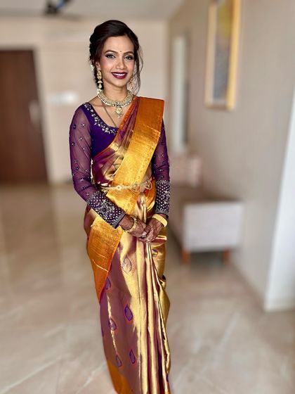 A full-length view of this gorgeous Marathi bridal look. The makeup is coordinated with the rich colors of her saree, creating a cohesive and stunning appearance.