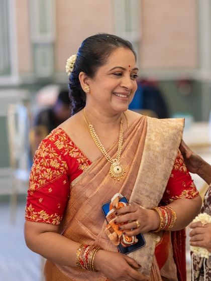 The joy of a mother on her daughter's big day, beautifully captured. Her saree is a testament to timeless elegance.