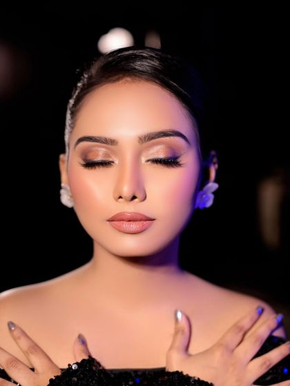 A serene and beautiful shot showcasing a soft glam look. The focus is on the flawless, dewy skin and the subtle shimmer on the eyelids, creating an ethereal glow.