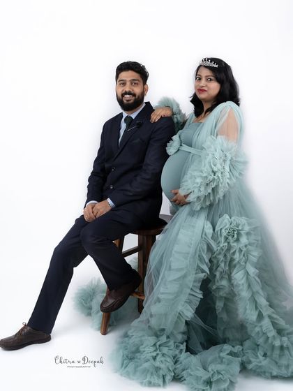 A formal and regal portrait. The couple poses elegantly, with her flowing gown and tiara creating a sophisticated look.