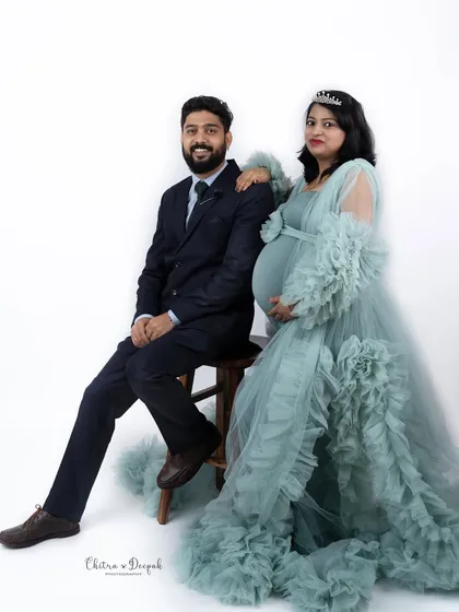 A formal and regal portrait. The couple poses elegantly, with her flowing gown and tiara creating a sophisticated look.