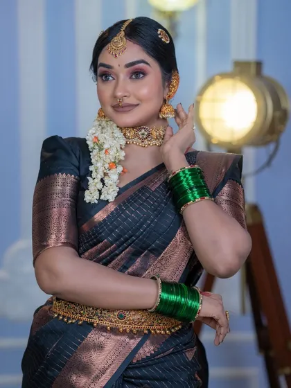 The complete look, showing how the makeup, black silk saree, gold waist belt (vaddanam), and green bangles all come together for a cohesive and elegant bridal appearance.