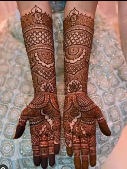 This beautiful bridal mehndi extends up the arms, featuring a mix of traditional motifs and fine-line details for a stunning result.