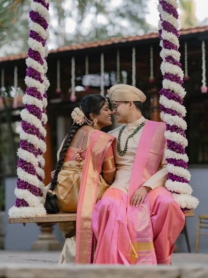 An intimate portrait of a couple on the floral-decorated swing, capturing their love amidst traditional decor.