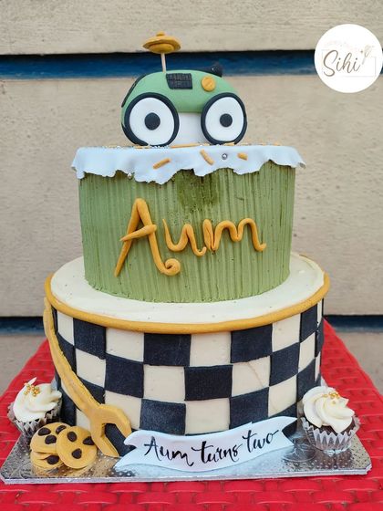I can't figure out what this vehicle is supposed to be, but it was fun to make. This two-tier cake for a second birthday features a checkered flag pattern and a mysterious green car topper.