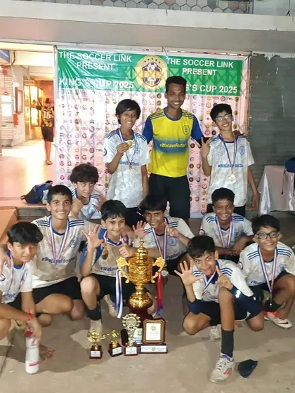 Our victorious U13 team celebrates with their coach and the winner's trophy after a hard-fought tournament. Their smiles and cheers capture the pure joy of winning as a team.