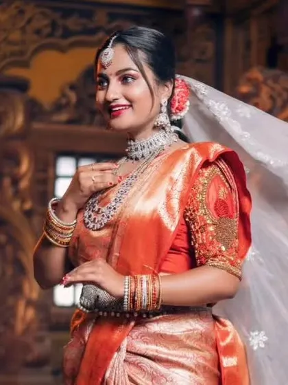A model looking radiant in an orange saree, complemented by our ruby and American diamond layered necklace set.