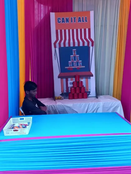 No carnival is complete without games. We provide classic game stalls like this 'Can It All' tin can toss, complete with a colorful booth and all necessary props.