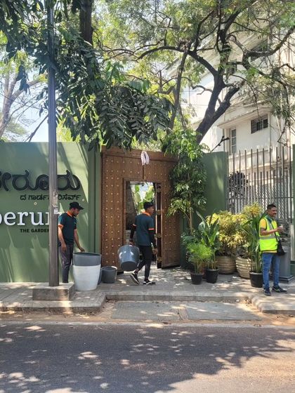The storefront view from Lavelle Road shows how the design creates a distinct and intriguing presence. The green wall and large wooden door stand out, signaling a unique destination for garden lovers.