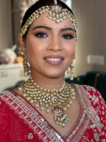 A detailed shot of the bridal makeup, showing the soft smokey eye and matte lip that perfectly balances the heavy kundan jewelry for this beautiful Gujarati bride.