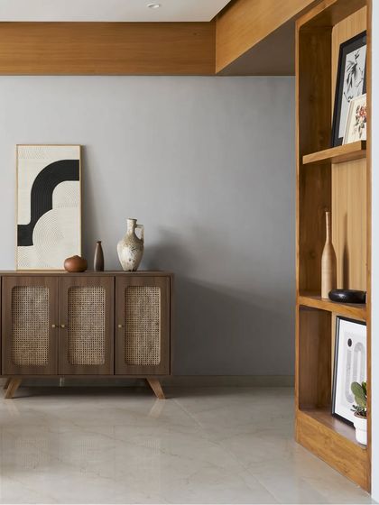 This rattan and wood credenza provides stylish storage while maintaining the room's light and natural aesthetic. The use of cane adds texture and warmth, complementing the clean lines of the surrounding decor.