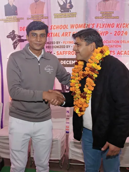 A handshake of respect with an official at the Delhi School Women's Flying Kick Sports Martial Art Championship.