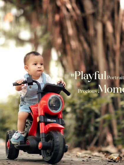 Playful portraits preserving precious moments. This little boy is on the move on his red toy motorcycle during a fun outdoor session.