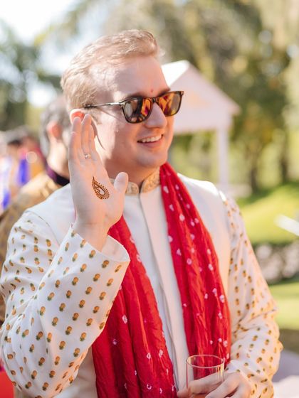 A cool shot of the groom showing off his simple henna design, embracing the traditions with a modern vibe.