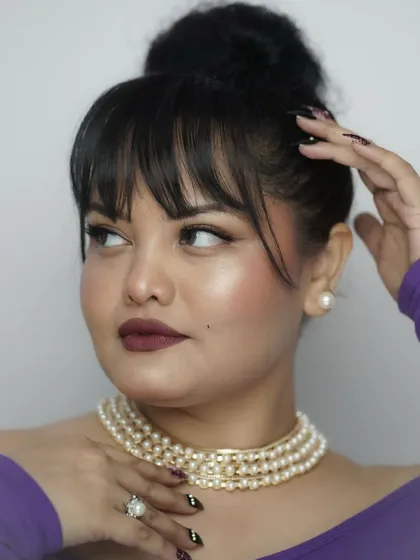 A closer look at the details. The pearl necklace and earrings add a classic touch, while the modern nail art shows that style is all about personal expression.