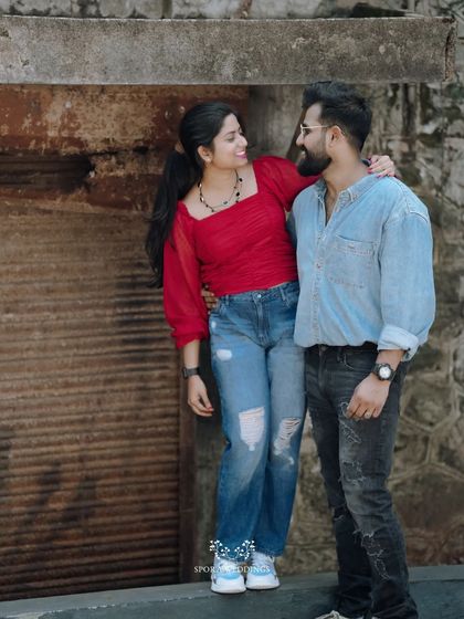 The couple posing against a rustic stone wall, their relaxed and happy interaction making for a great portrait.