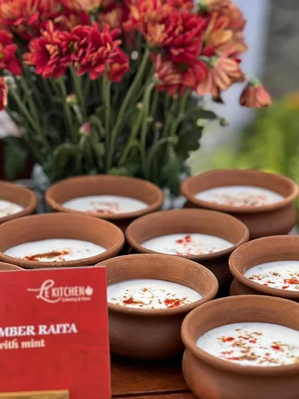 Cool and refreshing Cucumber Raita served in individual terracotta bowls, a perfect accompaniment to our spicy Indian main courses.