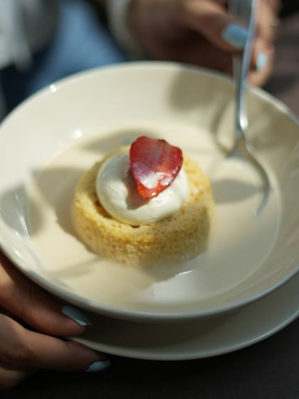 My Tres Leches cake is a light sponge soaked in three different kinds of milk, making it incredibly moist and decadent. It's topped with whipped cream and a fresh strawberry.