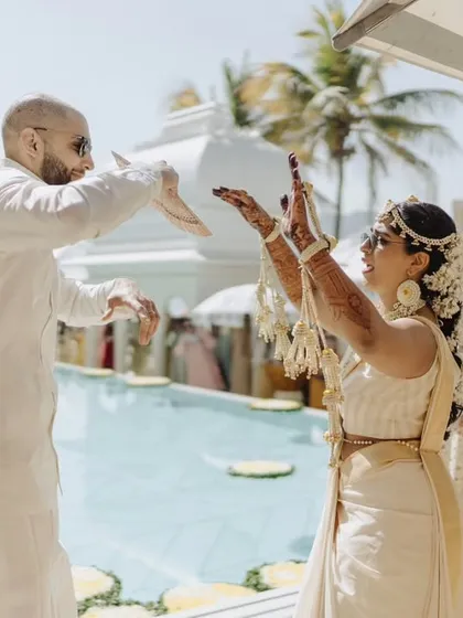 The bride and groom dancing by the pool during their Haldi event. We design our event layouts to make use of all the beautiful features of a venue, like this stunning poolside space.