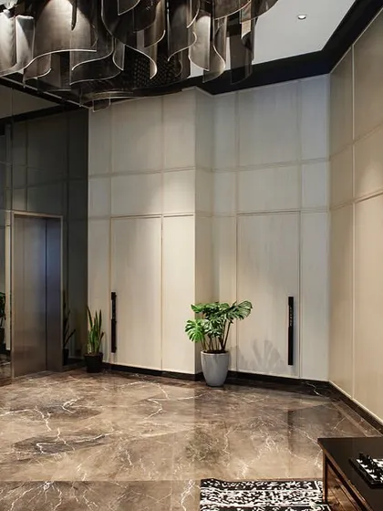 The lobby's design uses a neutral palette with white veneer walls and dark marble flooring, creating a sophisticated backdrop for the custom lighting and furniture.