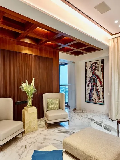 Beauty in simplicity. This cozy seating nook demonstrates how we combine subtle materials with effective lighting. The rich wood paneling and coffered ceiling are highlighted by ambient light, creating a warm and inviting corner.