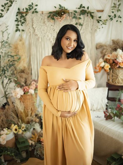 A bright and happy portrait of a mother-to-be in a beautiful mustard yellow gown. Her smile lights up the room in this sunny boho-themed session.