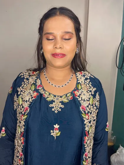 A soft glam look for this client in a beautiful embroidered blue outfit. The makeup features a warm-toned eyeshadow and a glossy lip.