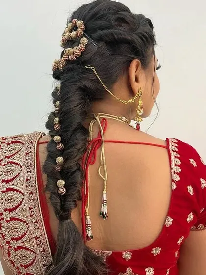 Our curriculum also includes bridal hairstyling. Here, you can see an intricate fishtail braid adorned with hair accessories, a popular choice for modern North Indian brides.