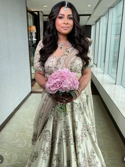 Soft, voluminous waves for a bride holding a bouquet, a timeless and romantic wedding day style.