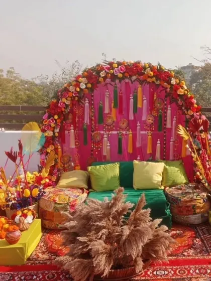 A perfect rooftop Mehandi setup with a vibrant, bohemian vibe. We used a floral arch, colourful tassels, low seating with gaddas, and lots of props for a festive and photogenic event.