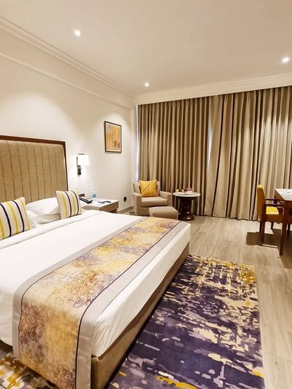 Another view of a suite at Vivanta Bengaluru, highlighting the custom bed runner and abstract rug that we designed. The vertical-striped upholstered headboard adds texture and height to the room.