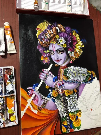 Adding more color and detail to the Krishna painting. The orange cloth and flower garlands are starting to take shape.