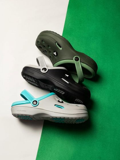 A colorful flat-lay of three pairs of clogs. The diagonal composition and contrasting green and white background make this a vibrant, eye-catching shot.