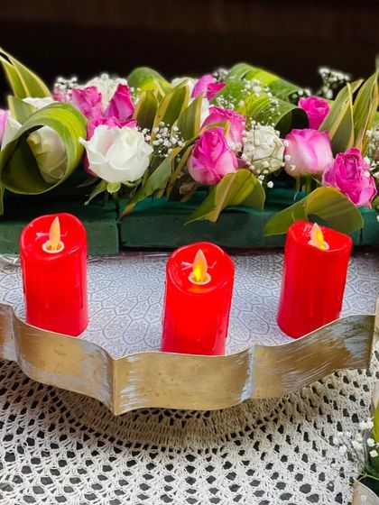 An elegant urli centerpiece combining a fresh floral arrangement with flameless LED candles. This is a great option for achieving a beautiful, long-lasting, and safe candlelit glow.