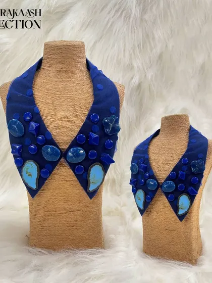 A bold, geometric statement collar in a deep royal blue. This piece is embellished with a variety of polished blue and turquoise-colored stones in different shapes and sizes.