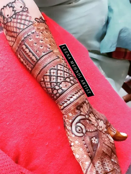 This design shows how a pattern can flow beautifully up the arm. It combines traditional paisleys and lotuses with modern geometric fillers for a balanced and elegant bridal look.