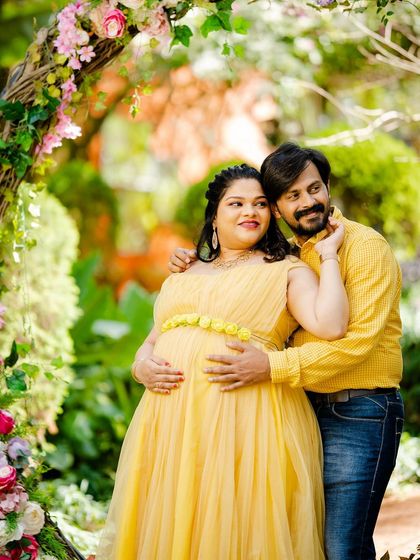 A playful and romantic interaction between the couple, framed by flowers. Capturing these unscripted moments of joy is a key part of my approach to couple maternity shoots.