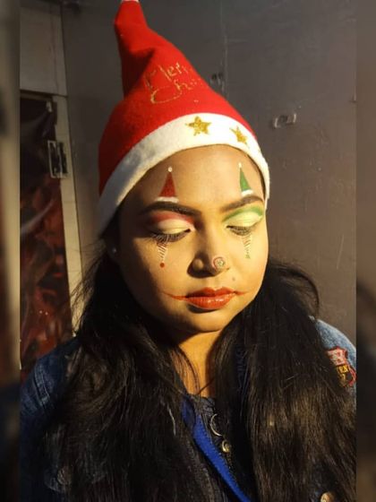 Another creative take on Christmas makeup. This student designed a jester-inspired look using festive red and green colors, demonstrating their skill in symmetrical design and character creation.