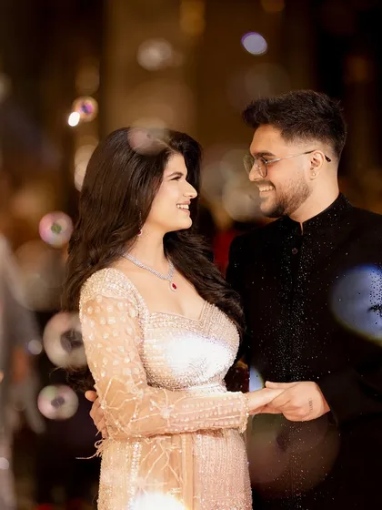A magical and dreamy shot with bubble bokeh effects. The soft, out-of-focus lights surrounding the couple add a whimsical and celebratory feel to this happy engagement portrait.