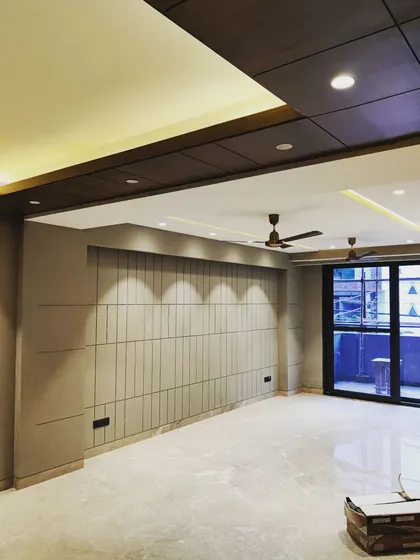 The final look of a living room interior in a recently completed project. This image shows our attention to detail in the finishing stages, from the clean lines of the wall paneling and false ceiling to the seamless integration of lighting, creating a calm and sophisticated space.