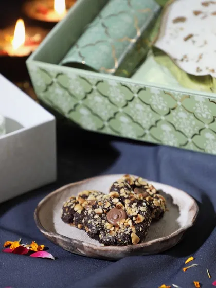 A festive crunch in every bite. This shot showcases our hazelnut cookies next to one of our beautifully packaged Diwali gift boxes.