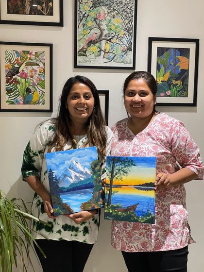 Two friends show off their beautiful landscape paintings, created side-by-side in our studio.