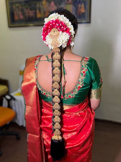 A view of the intricate traditional South Indian bridal braid, adorned with flowers and gold accessories.