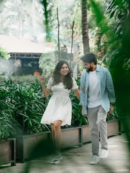 A happy, walking shot of the couple hand-in-hand through a park. The natural light filtering through the trees adds a magical quality to this candid moment.