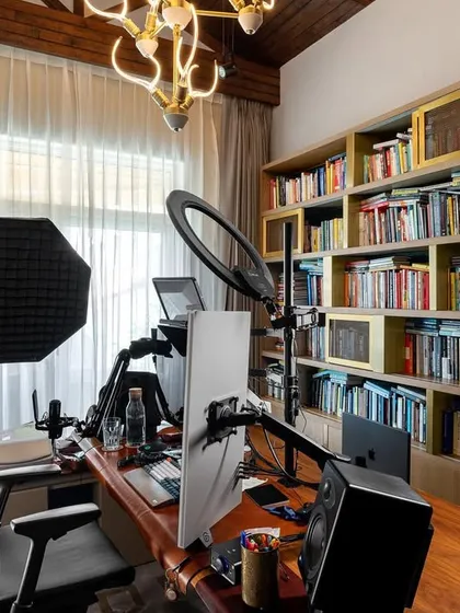For a client with varied interests including podcasting, we designed this functional and inspiring home office. The space includes a professional recording setup, ample soundproofing, and a large bookshelf, all within a warm and elegant environment.