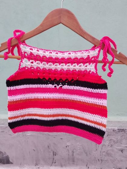 A custom-made halter top with colorful stripes and a delicate white lace detail at the top.