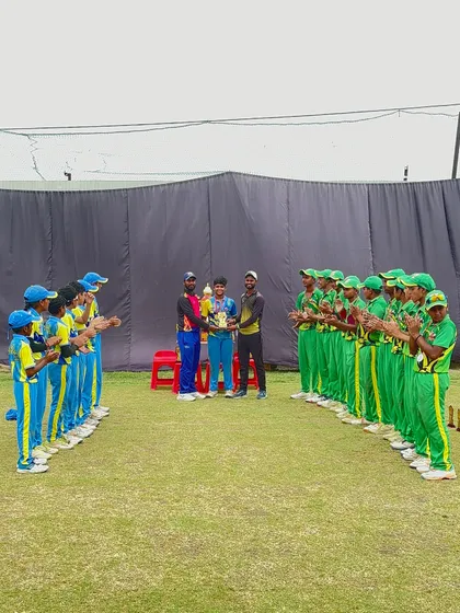 The team applauds their captain and the trophy.